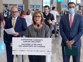 Parliamentary Secretary for Transport and Liberal MP Annie Koutrakis, centre, speaks as Calgary Airport Authority CEO Bob Sartor, left, and Liberal MP George Chahal look on during a funding announcement in Calgary, Tuesday, Aug. 23, 2022.