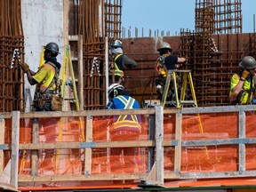 Workers on a condo building under construction in downtown Victoria, British Columbia, Canada, on Thursday, April 7, 2022. Benchmark home prices rose a record 3.5% in February, with transactions jumping 4.6% during the month, according to data from the Canadian Real Estate Association.