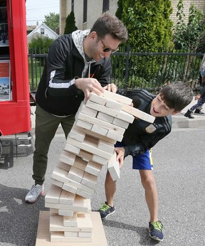 Attendees of the 2019 Dropped On Drouillard street festival play a game of giant Jenga.