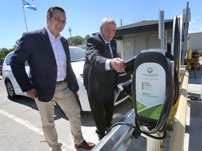 MP Irek Kusmierczyk, left, and Windsor city Coun. Ed Sleiman check out an EV charger at the city's Environmental Services depot on Friday, August 12, 2022 during a press conference.