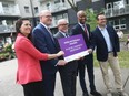 From left: Michelle Coulis, director of corporate services and interim CEO of Windsor Essex Community Housing Corporation, Windsor Mayor Drew Dilkens, Essex County Warden Gary McNamara,  Housing and Diversity and Inclusion Minister Ahmed Hussen, and MP Irek Kusmierczyk (Liberal -- Windsor-Tecumseh) pose outside Fontainebleau Towers in Windsor on Thursday, Aug. 4, 2022.
