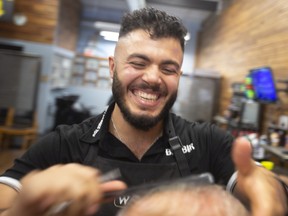 Silver Elia, owner of The Mane Station in Tecumseh, cuts a client's hair on Friday, August 19, 2022.