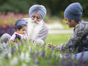 Mohinder Pal Singh visits the Queen Elizabeth II sunken garden at Jackson Park with his 7-month-old granddaughter, Adhab Singh, and daughter, Gurpinder Kaur, on Thursday, Aug. 4, 2022.