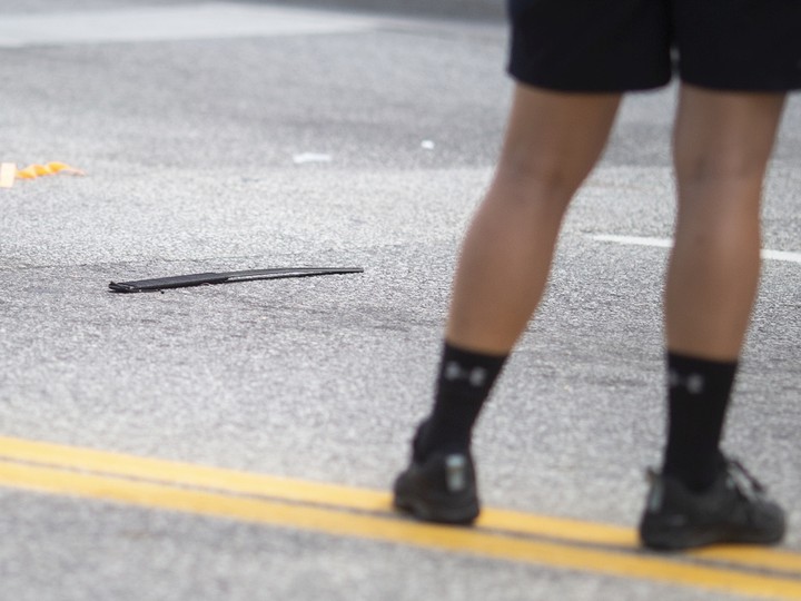  A Windsor police officer stands next to a machete a man was wielding at people before being shot by a Windsor police officer, at the intersection of Wyandotte Street and Ouellette Avenue, on Monday, August 15, 2022.