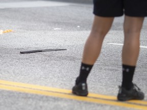 A Windsor police officer stands next to a machete a man was wielding at people before being shot by a Windsor police officer, at the intersection of Wyandotte Street and Ouellette Avenue, on Monday, August 15, 2022.