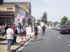 People opposing COVID-19 vaccination demonstrate outside a pediatrician's office on Howard Avenue in Windsor on Aug. 3, 2022.