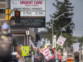 People opposed to the COVID-19 vaccine and vaccine mandates protest outside an urgent care clinic on Howard Avenue on Wednesday, Aug. 3, 2022.