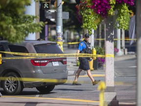 WINDSOR, ONTARIO:. AUGUST 16, 2022 - A Windsor police officer remains on scene of an officer involved shooting death at the intersection of Ouellette Avenue and Wyandotte Street, on Tuesday, August 16, 2022.