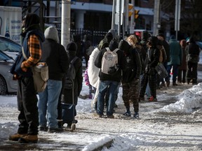 People line up last Christmas for a takeout meal from the Ottawa Mission. The pandemic made hunger and poverty in the community much worse than before COVID.