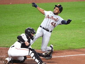 Adley Rutschman of the Baltimore Orioles catches the throw to home plate before tagging out Jeimer Candelario of the Detroit Tigers trying to score on Akil Baddoo's double in the fifth inning  during a baseball game at Oriole Park at  Camden Yards on September 20, 2022 in Baltimore, Maryland.