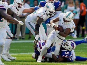 Tua Tagovailoa of the Miami Dolphins is sacked by Greg Rousseau of the Buffalo Bills during the fourth quarter at Hard Rock Stadium on September 25, 2022 in Miami Gardens, Florida.