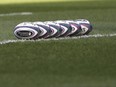Rugby balls lined up on the pitch.