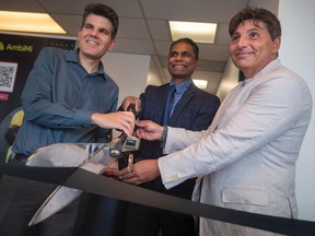From left, Andrew Dowie, MPP for Windsor-Tecumseh, Rakesh Naidu, CEO of the Windsor-Essex Regional Chamber of Commerce, and Mark Towers, president of AmbiMi Job Hun, cut the ribbon to officially celebrate the opening of their first job hub in Canada, on Howard Avenue in Windsor, on Friday, Sept. 16, 2022.