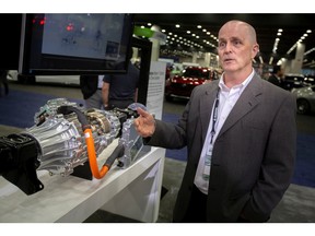 Mike Dowsett, Director of Electrification for Magna North America, talks about the Magna eBeam Electric Axle Drive System, pictured at left, at the 2022 North American International Auto Show at Huntington Place, on Wednesday, Sept. 14, 2022.