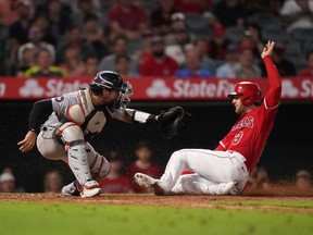 Los Angeles Angels right fielder Taylor Ward  slides into home plate to beat a throw to Detroit Tigers catcher Tucker Barnhart to score in the 10th inning at Angel Stadium.