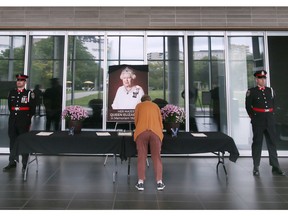 A woman signs a book of condolences to honour Queen Elizabeth II at Windsor City Hall on Monday, September 12, 2022. The book has been set up in the lobby of City Hall where it will remain for the next five days.