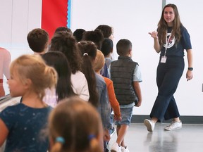 A staff member at the newly opened James L. Dunn Public School in Windsor guides students through a hallway on Tuesday, September 6, 2022.