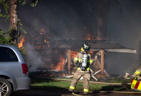 Un pompier surveille les flammes d'une maison dans le pâté de maisons 1100 de Walker Road à Windsor le 21 septembre 2022.