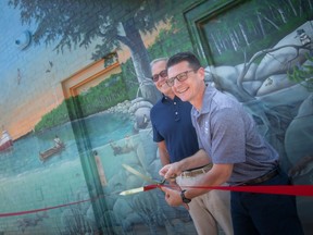 Amherstburg Mayor Aldo DiCarlo and Richard Peddie, cut the ribbon on the Our River, Our Home mural in King's Navy Yard Park, on Wednesday, Sept. 7, 2022.  Peddie, with his wife Colleen, sponsored the mural.