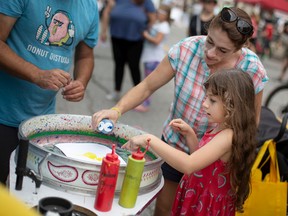 WINDSOR, ONT:. SEPT. 18, 2022 – Ashlee Cormier and her daughter, Skylah Cormier, 7, make some art with a paint spinner in downtown Windsor during Open Streets Windsor, on Sunday, Sept. 18, 2022.