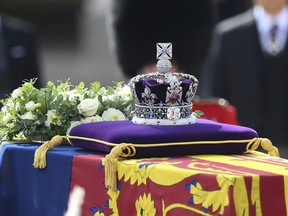 A view of the coffin of Queen Elizabeth II, adorned with a Royal Standard and the Imperial State Crown and pulled by a Gun Carriage of The King's Troop Royal Horse Artillery, during a procession from Buckingham Palace to Westminster Hall in London, Wednesday, Sept. 14, 2022.