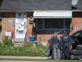 Windsor police officers surround a house at 4340 Wyandotte St. East on the morning of Sept. 8, 2022.