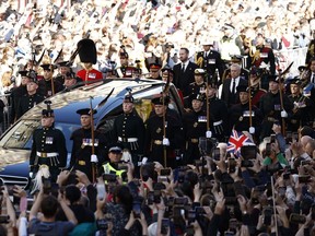 Crowd gather as the procession of Queen Elizabeth's coffin winds its way through the streets of Edinburgh, Scotland, Monday, Sept. 12, 2022.
