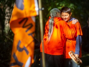 Theresa Sims, traditional Indigenous Knowledge Keeper and Elder, embraces Mgiizi Wright before he performs a hymn for all the children who died at the residential schools, during a community gathering at the Ojibway Prairie Complex to mark the National Day of Truth and Reconciliation, on Friday, Sept. 30, 2022.