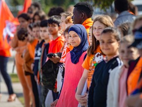 Grade six and seven students from Set-Therese Catholic Elementary School, form a line along Tecumseh Road to mark the National Day of Truth and Reconciliation, on Friday, Sept. 30, 2022.