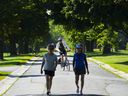 People walk down Morningside Lane in Ottawa on Wednesday, July 13, 2022. Don't put away your summer clothes yet. The Weather Network says there are still warm days ahead.Canadian Press/Sean Kilpatrick