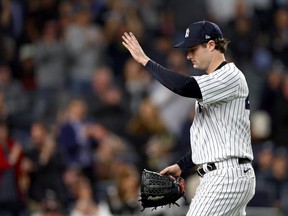Gerrit Cole of the New York Yankees waves to the crowd as he walks back to the dugout after being relieved against the Cleveland Guardians during the seventh inning in game one of the American League Division Series at Yankee Stadium on October 11, 2022 in New York, New York.