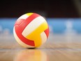 A volleyball on a wooden gym floor