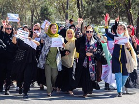 Afghan women display placards and chant slogans during a protest they call Stop Hazara Genocide a day after a suicide bomb attack at Dasht-e-Barchi learning centre, in Kabul on October 1, 2022.