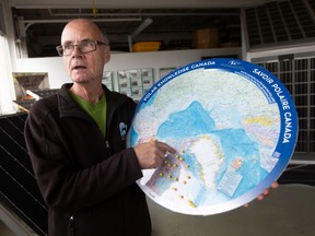 Klaus Dohring, president of Green Sun Rising, refers to a map of the arctic where his team is installing solar panels, on Thursday, Oct. 20, 2022.