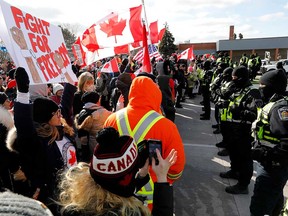 Police officers face Freedom Convoy supporters blockading the Ambassador Bridge in Windsor on Feb. 12, 2022.