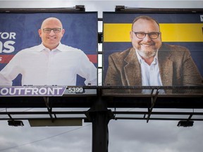 Large billboard signs of Windsor mayoral candidates, Drew Dilkens and Chris Holt, are pictured adjacent to each other at the intersection of Howard Avenue and South Cameron Boulevard, on Thursday, Sept. 29, 2022.