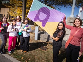 Build a Dream president, Nour Hachem-Fawaz, second from right, and her Build a Dream team, raise a flag for International Day of the Girl at Charles Clark Square on Tuesday, Oct. 11, 2022.
