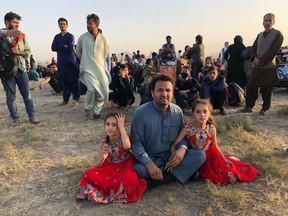 Afghan journalist Ghousuddin Frotan is shown with two of his daughters, Hela and Wranga, at Kabul International Airport on Aug. 16, 2021, shortly after Taliban militants entered Afghanistan's capital and took control. Thousands of Afghans flocked to the airport, desperate to get out of the country. (Photo courtesy of Ghousuddin Frotan)