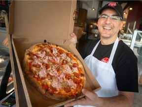 Roberto Porceddu, manager at Oven 360 in LaSalle, holds a freshly made meat lovers, on Tuesday, Oct. 18, 2022.