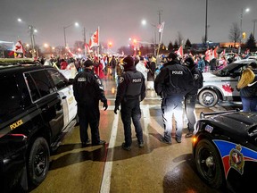 Police officers face protesters during the occupation that blocked access to the Ambassador Bridge in Windsor on Feb. 11, 2022.