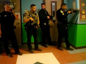 Police deploy in a hallway after a person entered Robb Elementary school, killing 19 children and two teachers in Uvalde, Texas, May 24, 2022 in a still image taken from police body camera video.