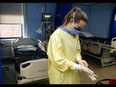 Nurse Courtney Benoit dons personal protective equipment before tending to a patient in the special-care unit of Campbellford Memorial Hospital in Campbellford, Ont. Spending on health care as a proportion of provincial budgets keeps growing, approaching 40 per cent. Luke Hendry/The Intelligencer/Postmedia Network