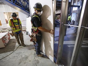 Construction workers install sheets of drywall at a building project in Calgary, Alta., Friday, Dec. 30, 2016. Experts say Alberta businesses are poised to face significant wage pressure in 2023 as the province is not keeping up with the rest of the country when it comes to wage increases.