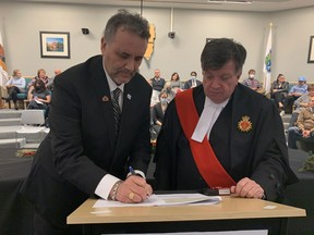 Judge George W. King watches Wednesday night as Tecumseh Deputy Mayor Joe Bachetti signs a statement after the county council elected him Essex County Deputy Mayor.