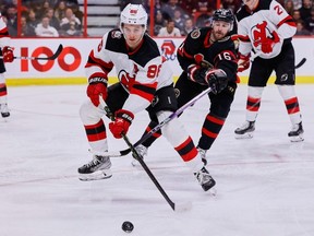 Ottawa Senators left wing Austin Watson checks New Jersey Devils center Jack Hughes during third period NHL action at the Canadian Tire Centre on Saturday, Nov. 19, 2022.