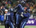 Toronto Argonauts defensive line Dewayne Hendrix (99) and Argos defensive back Shaq Richardson (1) celebrate on the field at the 109th Grey Cup at Mosaic Stadium. Walter Tychnowicz/USA TODAY SPORTS