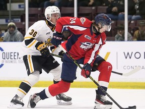 Le défenseur des Spitfires de Windsor, Bronson Ride (24 ans), protège la rondelle de Sasha Pastujov (36 ans) de Sarnia Sting lors de la première période du match de vendredi au Progressive Auto Sales Arena.  Mark Malone/Chatham Daily News/Réseau Postmedia