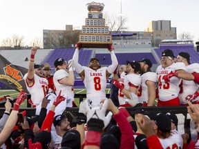 Kevin Mital of the Laval Rouge et Or hoists the Vanier Cup after a 30-24 win over the University of Saskatchewan in London on Saturday November 26, 2022. Mike Hensen/The London Free Press/Postmedia Network