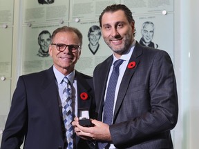 Chairman of the selection committee Mike Gartner presents the Hall of Fame ring to Roberto Luongo at the Hockey Hall Of Fame yesterday.
