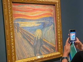 A visitor takes pictures of Edvard Munch's iconic painting "The Scream" at the National Museum in Oslo, Norway, Aug. 3, 2022.